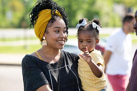 A student with her child outside at a JSU event
